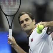 Roger Federer beats the balls after his victory.
