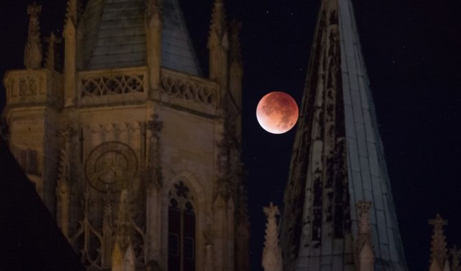 Der rötlich gefärbte Mond leuchtet am 28.09.2015 in Erfurt (Thüringen) hinter dem Dom. Der rötlich gefärbte Mond leuchtet am 28.09.2015 in Erfurt (Thüringen) hinter dem Dom. (Foto)