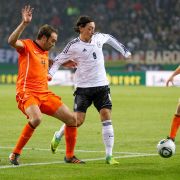 Duell der Ausrüster: Mesut Özil (rechts, in Adidas-Trikot und Nike-Schuhen) gegen Joris Mathijsen (Adidas-Schuhe und Nike-Trikot). Duell der Ausrüster: Mesut Özil (rechts, in Adidas-Trikot und Nike-Schuhen) gegen Joris Mathijsen (Adidas-Schuhe und Nike-Trikot).