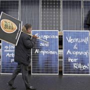 Ein Beschäftigter einer Solarfirma geht während einer Protestveranstaltung gegen die geplanten Subventionskürzungen für die Branche an bemalten Solartafeln im Solar Valley in Thalheim vorbei (Archivbild). Ein Beschäftigter einer Solarfirma geht während einer Protestveranstaltung gegen die geplanten Subventionskürzungen für die Branche an bemalten Solartafeln im Solar Valley in Thalheim vorbei (Archivbild).