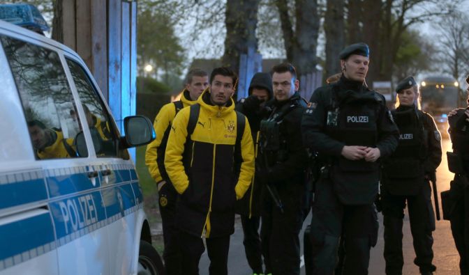 Spieler von Borussia Dortmund, darunter Sven Bender und Nuri Sahin, werden von Polizisten zum Hotel gebracht.
