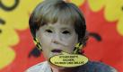 ... auch Kanzlerin Merkel, die unter Schwarz-Gelb die Laufzeiten von Kernkraftwerken verlängern will. Ein Demonstrant trägt eine Merkel-Maske und bezeichnet sie als Atom-Chaot. Auch andere Protestler ... Foto: dpa