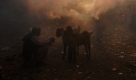 Ein Marktverkäufer wartet auf Kunden in Neu Dehli, Indien, während die Sonne untergeht. Foto: ap