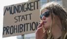 Ein Teilnehmer der Hanfparade zieht in Berlin vor einem Schild mit der Aufschrift Mündigkeit statt Prohibition an einer Zigarette. Mehrere Hundert Menschen haben sich am Samstag auf dem Berliner Alexanderplatz zu einer Demonstration mit dem Titel Hanfparade versammelt. Unter dem Motto 40 Jahre sind genug - BtMG ade! forderten die Teilnehmer die Abschaffung des Betäubungsmittelgesetzes (BtMG). Die Initiatoren verlangen stattdessen die Freigabe von Hanf als Rohstoff, Medizin und Genussmittel.
 Foto: dapd