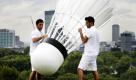 Jake Bernstone (links) und Adam Paris tragen einen überdimensionalen Federball auf dem Primrose Hill im Londoner Regent's Park, um für die vom 8. bis 14. August stattfindenden Badminton-Weltmeisterschaften zu werben. Der Federball ist ungefähr drei Meter groß und wiegt etwas mehr als 30 Kilogramm. Foto: dapd