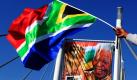 Ein südafrikanischer Fußballfan schwenkt die Flagge Südafrikas, während im Hintergrund einer Banner des ehemaligen Präsidenten Nelson Mandela installiert wird. Die Fußball-Weltmeisterschaft beginnt am 11.Juni. Foto: ap