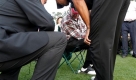 A rules official and Tiger Woods, right, examines his ball after it landed behind a patron's foot as he sat near the18th green during the first round of the Masters golf tournament at the Augusta National Golf Club in Augusta, Ga., Thursday, April 9, 2009. (AP Photo/Rob Carr) Foto: ap