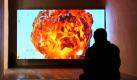 Ein Besucher sitzt im Kloster Unser Lieben Frauen in Magdeburg vor einer Leinwand und betrachtet das Video After the Crash von Hito Steyerl. Das Video ist eines von 50 Exponaten der Ausstellung Everyday Ideologies - Zeitläufe, Lebenswege, die gegenwärtig gezeigt wird. 
 Foto: dpa