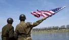 Ein Laiendarsteller in einer Uniform eines US-amerikanischen Soldaten des Zweiten Weltkrieges posiert am Samstag  im Rahmen des sogenannten Elbe Days am Elbufer in Torgau mit einer amerikanischen Flagge. Zum 65. Jahrestag des Zusammentreffens amerikanischer und sowjetischer Truppen im Mai 1945 an der Elbe wurden am Wochenende mehr als 20.000 Besucher begrüßt, darunter auch Veteranen des historischen Treffens sowie Nachkommen und offizielle Delegationen. Am 25. April 1945 hatten sich amerikanische und sowjetische Soldaten auf einer zerstörten Elbbrücke südlich von Torgau getroffen.
 Foto: ddp