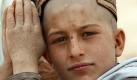 Ein afghanischer Junge beobachtet ein Treffen zwischen US-Soldaten und afghanischen Farmern.  Foto: ap