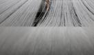 In Arbeit untergegangen ... ein chinesischer Fabrikarbeiter ist hinter den Fäden seines Webstuhls kaum noch zu sehen. Foto: How Hwee Young Foto: dpa