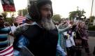 A Pakistani police officer walks ahead of protesters trying to reach the U. S. embassy in Islamabad, Pakistan to condemn the arrest of alleged Al-Qaida suspect Aafia Siddiqui on Thursday, Sept. 23, 2010. Siddiqui's strange legal odyssey began two summers ago in Afghanistan, where she turned up carrying evidence that _ depending on the argument _ proved she was either a terrorist or a lunatic.(AP Photo/B.K.Bangash)  Foto: ap