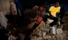 Leben in den Trümmern: Männer sitzen auf denResten eines Hauses in Cité Soleil, einem erdbebenzerstörten Viertel in Haitis Hauptstadt Port-au-Prince. Foto: ap