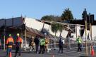 Rettungskräfte stehen vor einem eingestürzten Gebäude in Christchurch. Am Montag wurde die Stadt in Neusseeland erneut von einem Erdbeben erschüttert. Foto: dpa