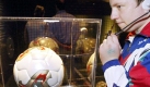 Ein Junge hört im historischen Museum in Speyer am Montag (31.05.2004) konzentriert auf die Audiophonie-Erklärung zu dem in einer Glasvitrine ausgestellten 'Fevernova'-Ball der Fußball-Weltmeisterschaft von 2002. Der Ball war der Spielball vom Spiel Spanien gegen Paraguay. Vom 31.05. -17.10.2004 ist die Ausstellung «Am Ball der Zeit - Deutschland und die Fußball-Weltmeisterschaften seit 1954» im historischen Museum in Speyer geöffnet. Sie zeigt Exponate, die Tragik und Triumphe der deutschen Elf seit der Fußball-WM 1954 illustrieren. Foto: Ronald Wittek dpa/lrs Foto: dpa