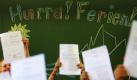 Schüler einer ersten Klasse der Adalbert-Stifter-Volksschule in Kaufbeuren (Schwaben) zeigten heute jubelnd ihre Zeugnisse. Für mehr als 1,6 Millionen Schüler in Bayern ging an diesem Freitag das Schuljahr zu Ende. Foto: dpa