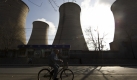 A man cycles past cooling towers of a coal-fired power plant in Beijing, China, Wednesday, Dec. 2, 2009. The U.N.'s environment chief said Tuesday he is optimistic that the climate change talks beginning in Copenhagen next week will reach a deal setting firm targets to cut carbon emissions. (AP Photo/Alexander F. Yuan) Foto: ap
