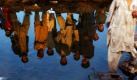 Afghanische Flüchtlinge spiegeln sich im Wasser eines kleinen Flusses in Rawalpindi, Pakistan. Foto: ap