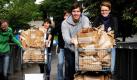 Mitarbeiter der Landeszentrale für Politische Bildung schieben im Stadtteil Weingarten in Freiburg im Rahmen der Aktion Wenn der Milchmann zweimal klingelt Einkaufswagen mit Frühstückstüten. Die Mitarbeiter klingeln an den Haustüren und überraschen die Anwohner zu früher Stunde mit einer Frühstücksbrezel, Milch und einem Grundgesetz. Mit dem Bildungsüberfall will die Landeszentrale für Demokratie werben und einer geringen Wahlbeteiligung entgegensteuern. Foto: dapd