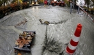 Schlammiges Wasser läuft vor dem hessischen Finanzministerium in Wiesbaden in einen Kanal. Bei einer Erdwärmebohrung wurde am Vortag versehentlich in 130 Meter Tiefe eine unter Druck stehende Wasserblase getroffen. Foto: dpa