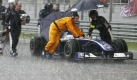 Durch den Monsun:Mechaniker bewegen bei strmenden Regen einen Williams auf der Rennstrecke. Foto: dpa