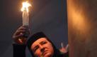 Mit dem Licht gegen das Dunkel: Eine orthodoxe Nonne in der Grabeskirche in Jerusalem. Foto: Atef Safadi Foto: dpa