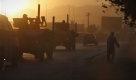 An Afghan man sweeps the road as a convoy of military vehicles are seen in the road in Kabul, Afghanistan, Saturday, Oct. 24, 2009. (AP Photo/ Gemunu Amarasinghe) Foto: ap