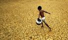 Ein indischer Junge läuft mit einem leeren Wasserkanister über ein trockenes Feld. Der heutige Internationale Tag des Wassers steht unter dem Motto Sauberes Wasser für eine gesunde Welt. Foto: ap