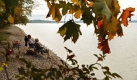 Ein älteres Ehepaar sitztin Ambach am Starnberger See am Ufer und genießt bei milden Temperaturen das sonnige Wetter, während die Blätter der Bäume bereits beginnen, sich herbstlich rot und gelb zu färben. Foto: ddp