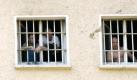 Strafgefangene stehen am Freitag (25.06.10) im Jugendgefaengniss in Ichtershausen an vergitterten Fenstern. Das Fussballturnier mit dem studentischen Verein Spirit of Football bildete am Freitag den Hoehepunkt eines sportlichen Aktionstages in der Jugendstrafanstalt Ichtershausen. Nach Angaben des Thueringer Justizministeriums sollen die jungen Gefangenen dabei Teamgeist und Durchhaltevermoegen entwickeln. Foto: Jens-Ulrich Koch/ddp Foto: dapd
