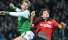 Bremens Mertesacker (l.) erzielt per Kopf das 2:2, Bayers Manuel Friedrich hat das Nachsehen. Foto: dpa