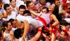 Eine Frau wird von anderen Feierwütigen während des Chupinazo, der offiziellen Eröffnung des San Fermin-Festes im spanischen Pamplona, auf Händen getragen. Das seit 1591 stattfindende Fest ist eine Touristenattraktion: Vor allem die nachmittäglichen Stierkämpfe ziehen tausende Touristen an.  Foto: ap