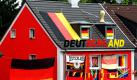 Für die Fußball-Weltmeisterschaft in Südafrika hat ein Essener Hauseigentümer direkt an der Autobahn 40 sein Haus geschmückt. Mit Deutschlandfahnen und dem Weltpokal auf dem Dach ist es ein Blickfang für viele tausend Pendler, die jeden Tag auf dem Weg zur Arbeit an diesem Haus vorbeikommen. Foto: dpa