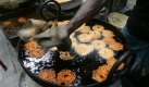 Ein Straßenverkäufer frittiert Süßigkeiten auf den Straßen Kalkuttas in Indien. Foto: ap
