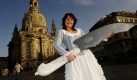Das Dresdner Stollenmädchen Christine Herrmann posiert vor der Frauenkirche in Dresden mit dem Großen Dresdner Stollenmesser. Das 1,60 Meter lange und 12 Kilogramm schwere Messer, das zu den größen seiner Art weltweit gehört, ist neben dem Riesenstollen eine der Attraktionen des Dresdner Stollenfestes. Foto: ddp