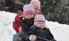 Die drei Schwestern Annalena (l.), Pauline (M.) und Charlotte sausen bei dichtem Schneetreiben den Maindamm in Gustavsburg herunter.
 Foto: ddp