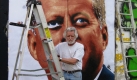 Der kalifornische Künstler Kent Twitchell posiert vor einem riesigen Porträt von John F. Kennedy in Los Angeles. Seine Mauerbilder sind Teil von The Wall Project, einer Kunstaktion, mit der in Los Angeles des 20. Jahrestages des Berliner Mauerfalls gedacht wird. 
 Foto: dpa