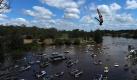Ein Felsenspringer beim Sprung von einer 27,5 Meter hohen Plattform in den Hawkesbury River in Australien. Foto: Dean Lewins Foto: dpa