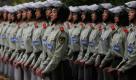 Chinesische Polizisten gehen vor einem Stadion in Peking in Formation, in dem gerade ein Fußballspiel ausgetragen wird.  Foto: ap