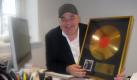 Der Däne Henrik Knudsen hält eine Goldene Schallplatte von Elvis Presley in den Händen. In einem Industriegebiet in Dänemark hat er das legendäre Graceland nachgebaut - und hofft auf viele zahlende Besucher. Foto: dpa