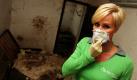 Nur mit Atemmaske kann Fernsehmoderatorin Sonja Zietlow sich in ihrem Haus in Nollenbach im Kreis Vulkaneifel noch umschauen. Das Gebäude hatte sie im August 2009 an eine angebliche Tierschützerin vermietet. Zeitweise lebten bis zu 70 Hunde in dem Anwesen und verwüsteten es völlig.  Foto: dpa