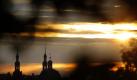 Wie gemalt: Die Türme der Stift-Haug-Kirche stehen in Würzburg im Licht der aufgehenden Sonne. Foto: Karl-Josef Hildenbrand Foto: dpa