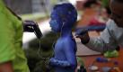 Der Körper als Leinwand:Ein Junge unterhält sich mit einem Video, während ein Künstler beim 5. Internationalen Fonambules Body Paint Festival in Mexico City seinen ganzer Körper bemalt. 2010 stehen vorkolonialistische Motive auf dem Programm. Foto: ap