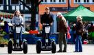 Touristen sehen auf dem Domplatz in Erfurt zwei Segway-Fahrern hinterher. Die Stadt Erfurt bietet seit heute Stadttouren mit den einachsigen Zweirädern an, die sich intuitiv bewegen lassen. Der bis 20 km/h schnelle Elektroroller hat eine Reichweite von 38 Kilometern, ein Mopedführerschein ist erforderlich. Foto: dpa