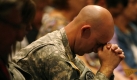 U.S. Army Sgt. Andrew Sobecky bows his head during the singing of 'Amazing Grace,' during a prayer service at First Baptist Church, Sunday, Nov. 8, 2009, in Killeen, Texas. Governor Rick Perry delivered a message to attendees from area churches during the service that honored the dead and wounded from last weeks mass shooting on Fort Hood. (AP Photo/Tony Gutierrez) Foto: ap