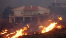 Wenige Kilometer von Athen entfernt nähern sich die Flammen einem Wohnhaus. Viele Menschen klagen über Atembeschwerden. Foto: dpa