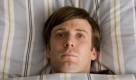 Schlummerstündchen eines Neurotikers. Brav gescheitelt wartet Phillip in gebügelt Bettwäsche auf den Schlaf. Morgens lässt er sich von der sanften Frauenstimme einer Bügelmaschine wecken. Foto: timebandits films
