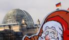 Ein Weihnachtsmann aus Pappe vor dem Berliner Reichstag (Symbolbild): Bundesbeamte sollen mehr Weihnachtsgeld erhalten. Foto: dpa