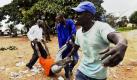 Männer tragen einen getöteten Aktivisten in der ugandischen Hauptstadt Kampala. Ein Feuer hat in der Nacht zuvor die historischen Königsgräber, die auch Unesco-Weltkulturerbe waren, zerstört. Gerüchte, dass es sich um Brandstiftung handeln könnte, zogen gewaltsame Unruhen nach sich. Foto: ap