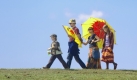 Demonstranten gehen am Pfingstsonntag auf einem Elbdeich in Richtung Atomkraftwerk Brokdorf zu einer Demonstration für eine sofortige Stilllegung aller Atommeiler in Deutschland. Die ursprünglich für das Pfingstwochenende geplante Blockade des Kraftwerks im Süden Schleswig-Holsteins mit mehreren tausend Demonstranten wurde um eine Woche verschoben, da der Kraftwerksbetreiber Eon die Revisionsarbeiten an dem Atomkraftwerk ebenfalls verlegt hatte. Foto: dpa